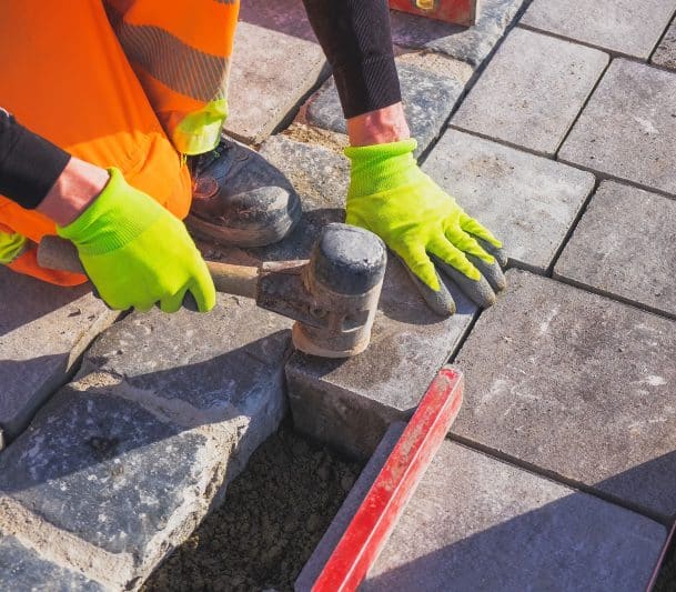 man repairing interlocking walkway